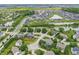 Expansive aerial view of a residential area with a pond and green spaces, illustrating a peaceful community layout at 2070 Mustang Chase Dr, Carmel, IN 46074