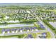 High-angle aerial view of a housing development, featuring numerous homes, serene ponds, and vast greenery, showcasing a balanced landscape at 2070 Mustang Chase Dr, Carmel, IN 46074