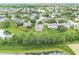 Overhead image highlighting a neighborhood's layout near a tranquil pond, featuring a lush tree line and green landscape features at 2070 Mustang Chase Dr, Carmel, IN 46074