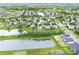 Comprehensive aerial view showcases a residential area near a pond, bordered by mature trees and green spaces at 2070 Mustang Chase Dr, Carmel, IN 46074