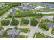 Overhead view of neighborhood with a pond, showcasing tree-lined streets and manicured lawns, creating a serene residential setting at 2070 Mustang Chase Dr, Carmel, IN 46074