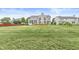 Expansive backyard showcasing a well-manicured lawn, mature trees, and a view of neighboring houses at 2070 Mustang Chase Dr, Carmel, IN 46074