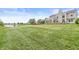 Picturesque backyard featuring a lush lawn, mature trees, and a view of a tranquil pond at 2070 Mustang Chase Dr, Carmel, IN 46074