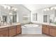 Bright bathroom featuring a soaking tub with tiled surround, double vanity, and neutral color palette at 2070 Mustang Chase Dr, Carmel, IN 46074