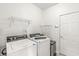 Practical laundry room with modern washer and dryer, overhead shelving, and a utility sink at 2070 Mustang Chase Dr, Carmel, IN 46074