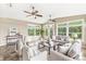 Inviting sunroom features lots of windows, ceiling fans, cozy seating, and peaceful backyard views at 2070 Mustang Chase Dr, Carmel, IN 46074