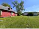 Expansive backyard with a red home, a detached garage, and lush green grass at 2115 S I St, Elwood, IN 46036