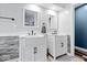 Bright bathroom featuring double sinks, modern fixtures, gray accent wall and hardwood floors at 241 Chamberlain Cir, Noblesville, IN 46062
