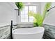 Bright bathroom featuring a soaking tub, natural light and modern fixtures and a gray accent wall at 241 Chamberlain Cir, Noblesville, IN 46062