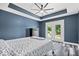 This primary bedroom features a ceiling fan, hardwood floors and an attached outdoor deck at 241 Chamberlain Cir, Noblesville, IN 46062