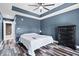 This primary bedroom features a ceiling fan, hardwood floors, blue walls and a dark dresser at 241 Chamberlain Cir, Noblesville, IN 46062
