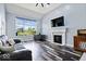 Spacious living room featuring a cozy fireplace, large window, and hardwood floors at 241 Chamberlain Cir, Noblesville, IN 46062