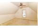 Attic bedroom with ceiling fan, carpeting and lots of light from the window, a perfect space for relaxing at 31 E Mill St, New Palestine, IN 46163
