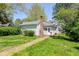 Cozy backyard featuring a brick pathway, green lawn, and mature trees at 31 E Mill St, New Palestine, IN 46163