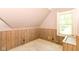 An upstairs bedroom with wood paneling and natural light from the windows, perfect for storage or a small bedroom at 31 E Mill St, New Palestine, IN 46163