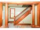 Traditional wooden staircase featuring decorative columns and a sunlit window at 31 E Mill St, New Palestine, IN 46163