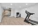 Spacious basement with modern floors, exposed brick, and fitness equipment is ready for your personal touch at 3215 N Pennsylvania St, Indianapolis, IN 46205