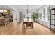 Dining room with hardwood floors, modern chandelier, view to the kitchen and back yard at 3215 N Pennsylvania St, Indianapolis, IN 46205