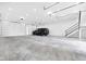 Spacious garage interior featuring a modern car and staircase, bathed in natural light from a large garage door at 3215 N Pennsylvania St, Indianapolis, IN 46205
