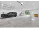 A spacious and well-lit garage interior featuring a car, staircase, and a large glass garage door at 3215 N Pennsylvania St, Indianapolis, IN 46205