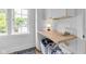 Functional laundry space with butcher block folding counter, white cabinets, and stylish storage solutions at 3215 N Pennsylvania St, Indianapolis, IN 46205