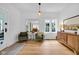 Bright living room with hardwood floors, a stylish sideboard, and comfortable seating area under a modern light fixture at 3215 N Pennsylvania St, Indianapolis, IN 46205