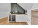 Stylish wet bar with a beverage fridge, butcher block countertop, and decorative tile backsplash at 3215 N Pennsylvania St, Indianapolis, IN 46205
