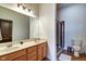Bathroom featuring a double sink vanity with wood cabinets, a framed mirror and a glass enclosed shower at 350 N Meridian St # A303, Indianapolis, IN 46204