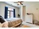 Comfortable bedroom with large window, neutral tones, and a ceiling fan at 350 N Meridian St # A303, Indianapolis, IN 46204