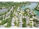 Aerial view of a neighborhood with lush green trees, manicured lawns, and a lake in the background at 3535 Clearwater Cir, Indianapolis, IN 46240