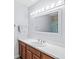 Bathroom with white countertops, wood cabinets, a mirror, and a shower with a patterned curtain at 3535 Clearwater Cir, Indianapolis, IN 46240