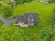 Aerial view of a large brick home on a green lawn, surrounded by mature trees and greenery at 3564 Clear Creek Blvd, Martinsville, IN 46151