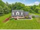 Aerial view of a charming brick home with a welcoming front porch and manicured landscaping at 3564 Clear Creek Blvd, Martinsville, IN 46151
