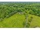 Scenic aerial view showcasing the house, extensive green lawn, mature trees, and winding driveway at 3564 Clear Creek Blvd, Martinsville, IN 46151
