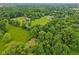 High angle shot showing home surrounded by lush greenery, mature trees, long driveway and neighboring homes at 3564 Clear Creek Blvd, Martinsville, IN 46151
