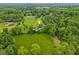 Majestic aerial view of home surrounded by green trees, manicured lawn and long paved driveway at 3564 Clear Creek Blvd, Martinsville, IN 46151