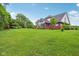 Wide view of the backyard, showcasing a large lawn, mature trees, and a swing set at 3564 Clear Creek Blvd, Martinsville, IN 46151