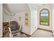 Attic bedroom features a comfortable chair and a natural wood framed arched window at 3564 Clear Creek Blvd, Martinsville, IN 46151