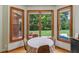 Cozy breakfast nook surrounded by windows, offering scenic views of the landscaped backyard at 3564 Clear Creek Blvd, Martinsville, IN 46151