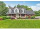 Charming two-story brick home with a welcoming front porch and lush landscaping at 3564 Clear Creek Blvd, Martinsville, IN 46151