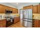 Kitchen featuring wood cabinets, stainless steel appliances and modern refrigerator at 3564 Clear Creek Blvd, Martinsville, IN 46151