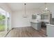 Dining area with wood-look flooring, a modern chandelier, and access to a fenced yard at 374 Pomona Ct, Greenfield, IN 46140