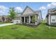 A beautifully landscaped side yard and covered porch enhance the curb appeal of this gray home at 395 Ehrlich Ln, Westfield, IN 46074