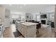 Bright kitchen island with stone countertops overlooks the dining and living areas in an open-concept design at 395 Ehrlich Ln, Westfield, IN 46074