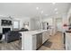 Bright kitchen with stone countertops and stainless appliances flows to the open living room with fireplace at 395 Ehrlich Ln, Westfield, IN 46074