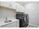 Bright laundry room with modern sink, countertops, cabinetry, and black washer/dryer at 395 Ehrlich Ln, Westfield, IN 46074