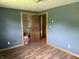 Bedroom with wood-look laminate flooring and adjacent walk-in closet at 409 W 3Rd St, Alexandria, IN 46001