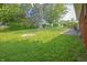 Lush green backyard with a fire pit, and mature trees, perfect for relaxation and outdoor activities at 412 S Norfolk St, Indianapolis, IN 46241