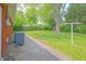 Brick exterior with lush backyard featuring mature trees and a concrete patio area at 412 S Norfolk St, Indianapolis, IN 46241