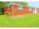 Red brick home exterior shows manicured lawn and colorful rose bush adding curb appeal at 412 S Norfolk St, Indianapolis, IN 46241